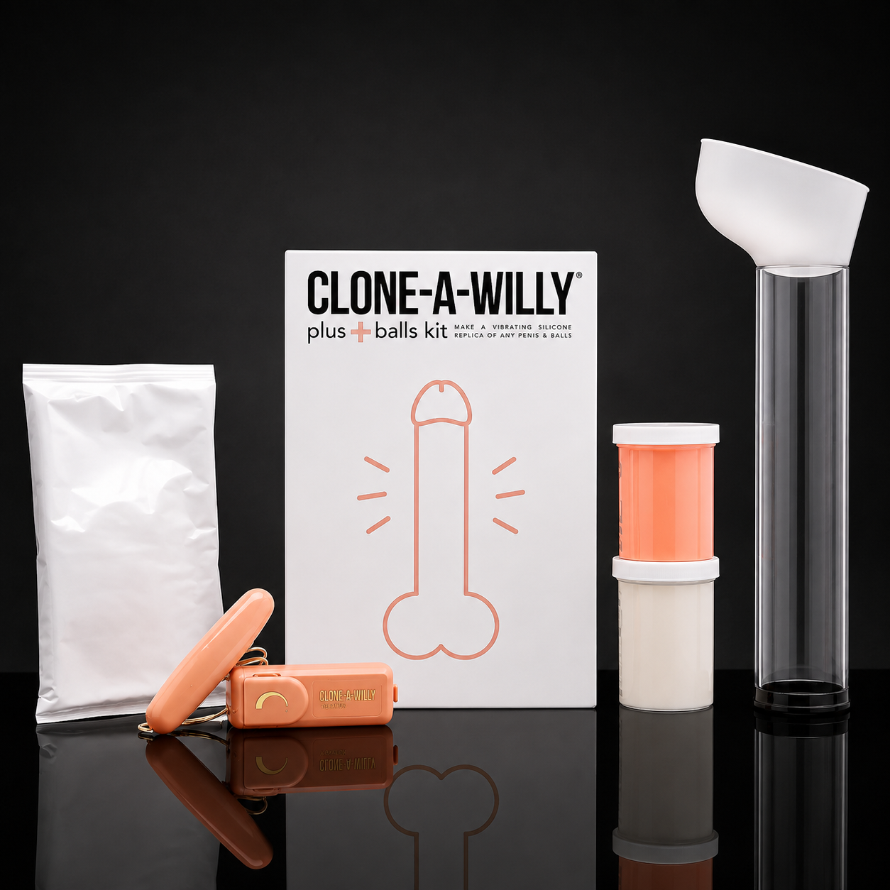 Clone-A-Willy plus balls kit displayed on a reflective black surface against a black background, including a white pouch, orange device, branded box, white funnel, and clear cylindrical container with orange insert.