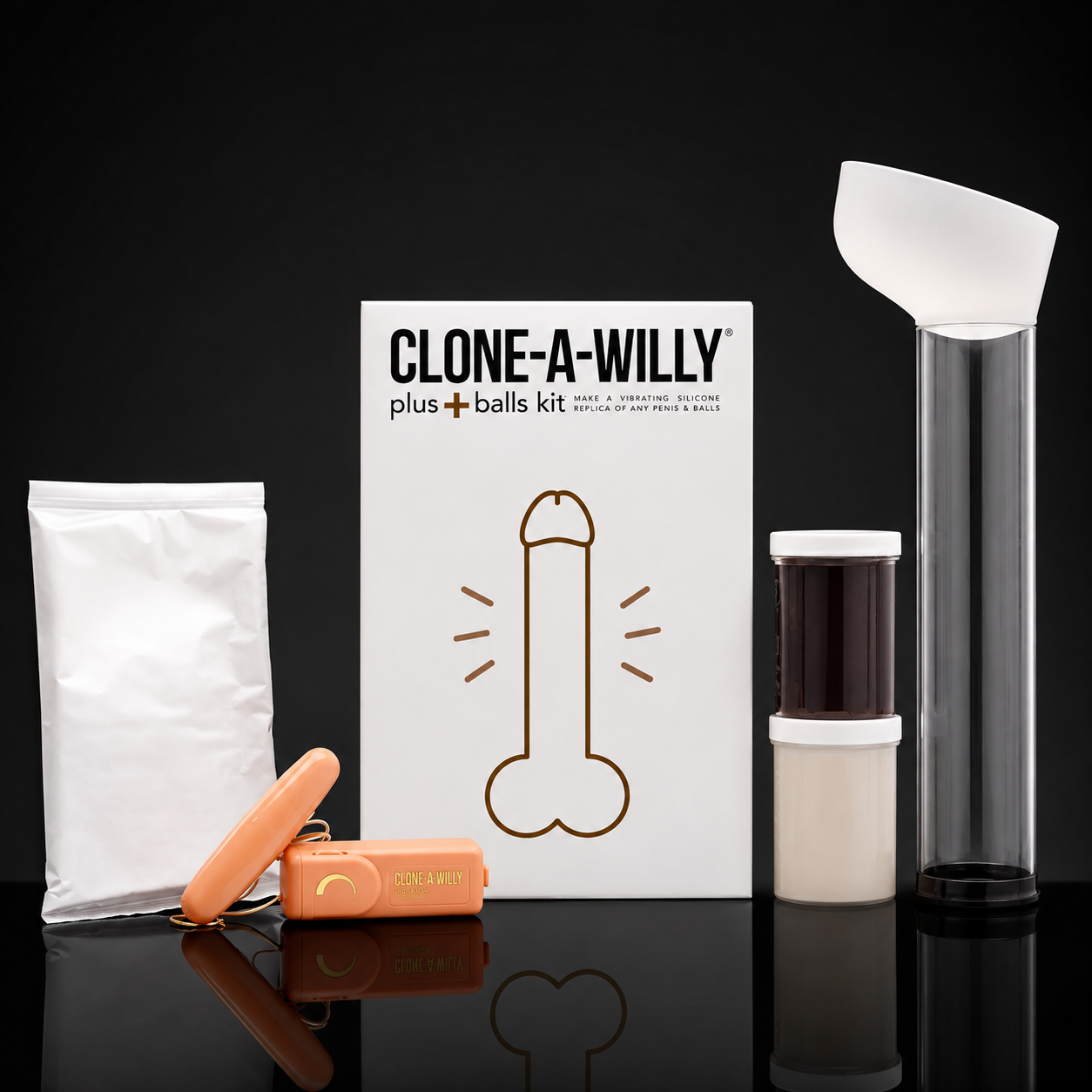 Clone-A-Willy Plus+Balls Kit displayed on a reflective black surface against a black background. The kit includes a white box with a brown phallic line drawing, an orange pouch, an orange cylindrical container, a clear cylindrical tube with a white scoop-like top, and a small jar with a white lid.